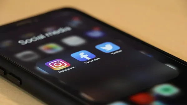 Smartphone displaying social media apps for content comparison