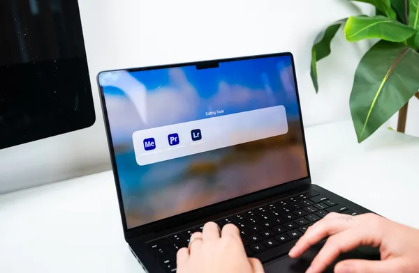 Content creator typing on laptop with video editing software